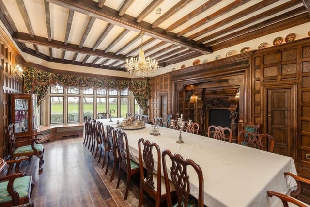 The stunning formal dining room has a wooden carved inglenook fireplace.