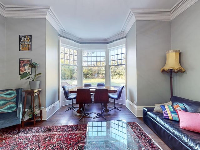 Large bay windows give lovely views of the mature lawned garden outside.