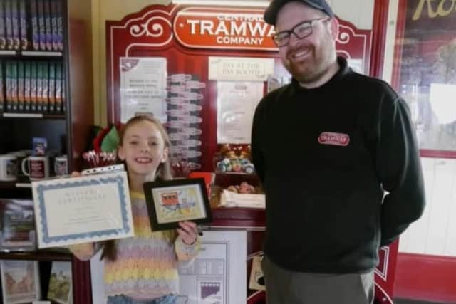 Anya Moore with her winning postcard in the Central Tramway Company's Easter competition, with General Manager Colin Powell.