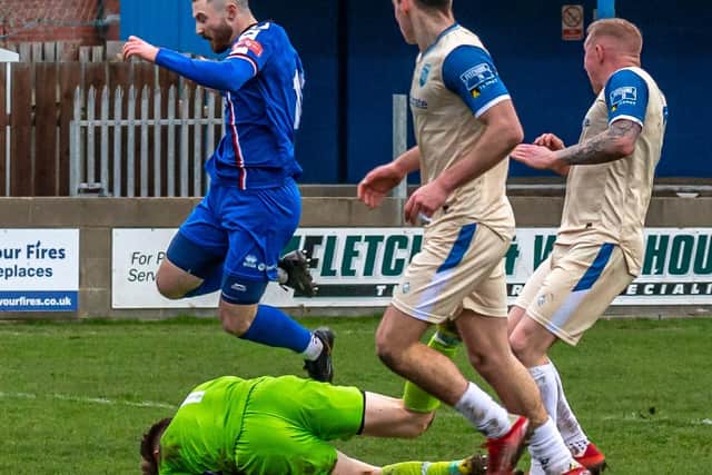 Blues substitute Bradley Fewster jumps over the Radcliffe keeper but is sent off.