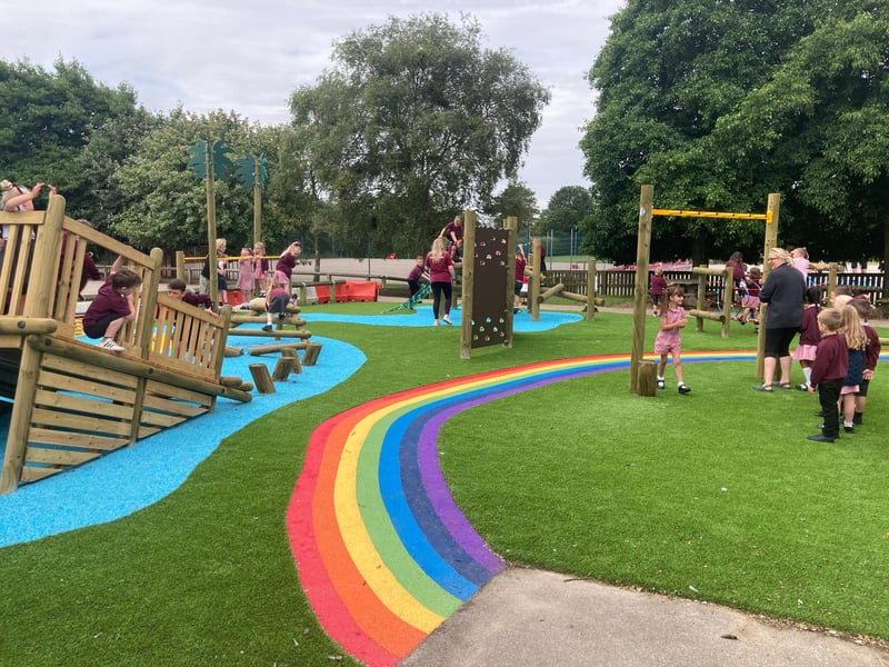 There is a beautiful rainbow that goes through the outdoor play area, making the space feel vibrant and fun.