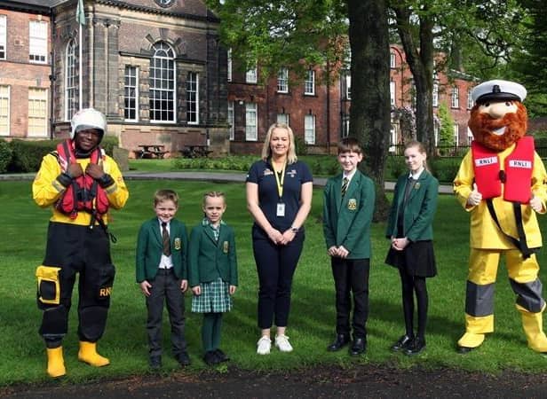 Helen Massey (centre) with pupils of Silcoates School, volunteer student Amir in RNLI inshore lifeboat crew kit and Stormy Stan - Image Courtesy of Silcoates School
