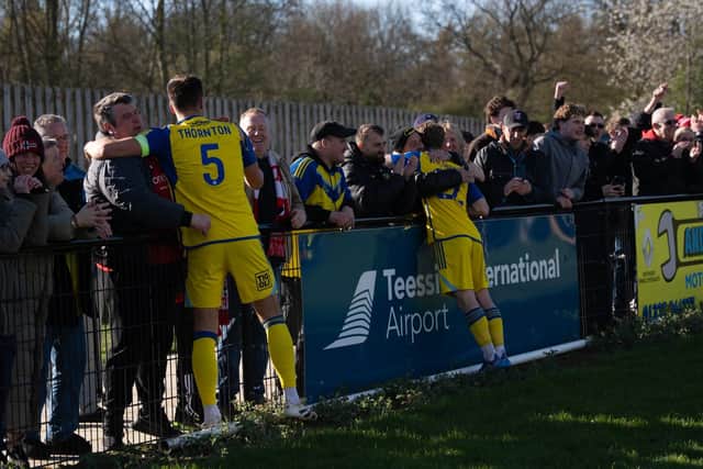 The travelling fans hug Will Thornton and teammate Jack Waldron in the post-match celebrations at Darlington on Good Friday. Photo by Wandering Photography