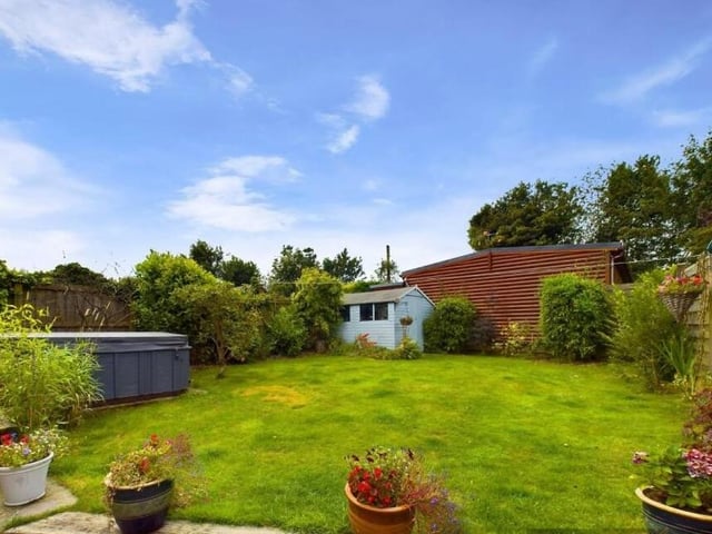 The lawned rear garden, with luxury hot tub.