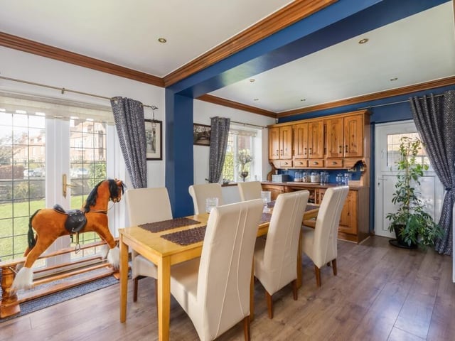A spacious dining room with French doors that lead outside to the garden.