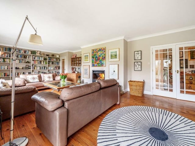 The lounge has fitted bookcases and an open feature fireplace.