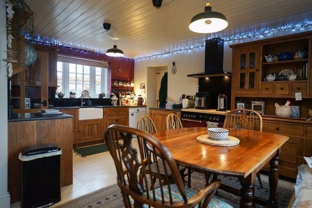 A farmhouse kitchen with oak units and a range cooker, that is open to the dining area.