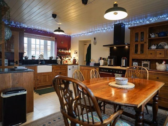A farmhouse kitchen with oak units and a range cooker, that is open to the dining area.