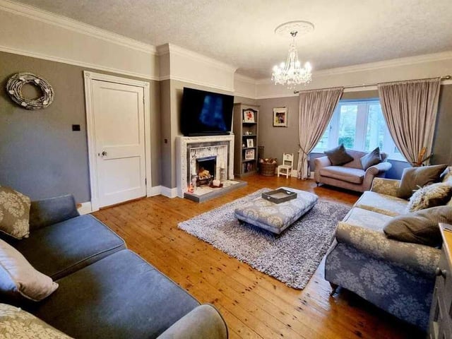 A spacious lounge with feature fireplace and bay window.