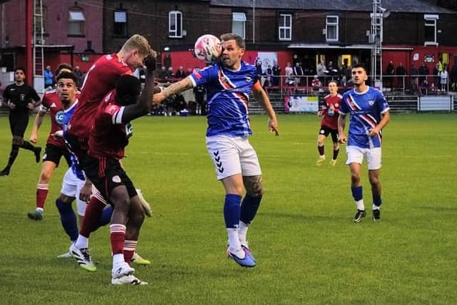 Whitby Town captain Stuart Rose keeps his eye on the ball during the defeat at Ashton United. Photo by Owen Cox