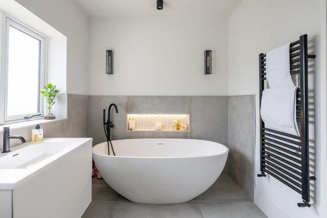 A free-standing oval bath features in this contemporary style bathroom.