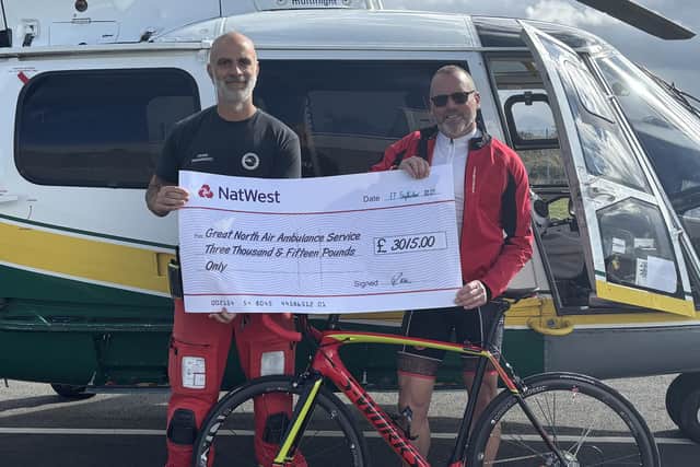 Cyclist Robert Wilson (right) from Sleights hands a cheque to Ian Grey, critical care paramedic with the Great North Air Ambulance.