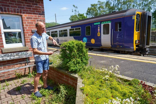 A couple live in a trainspotters' dream home - an old railway ticket office with its own level crossing and trains stopping outside their bedroom 12 times a day.