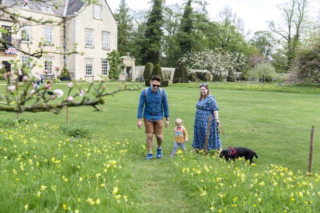 Young family walking around the garden during the Festival of Blossom event at Nunnington Hall, North Yorkshire