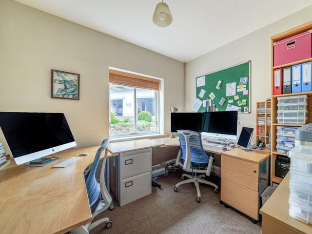 A home office that easily accommodates two desks and office furniture.