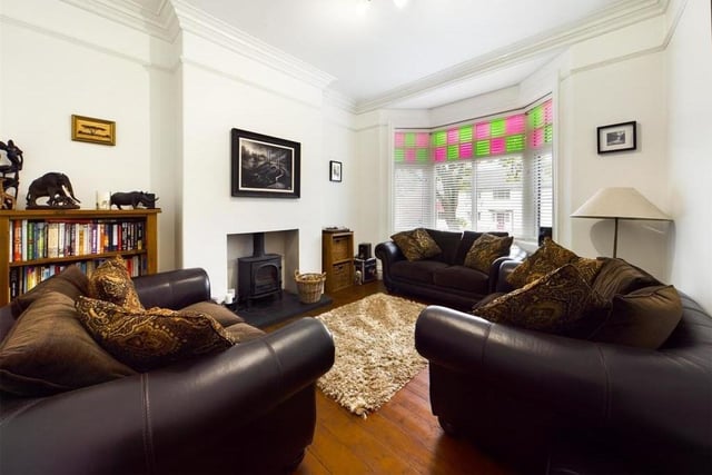 A stunning sitting room with bay window and feature fireplace.