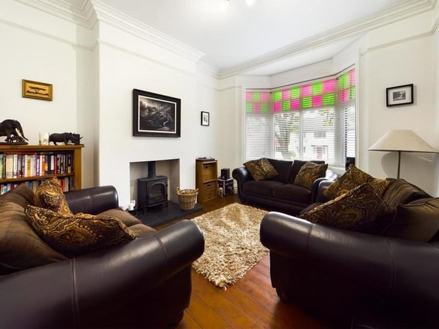 A stunning sitting room with bay window and feature fireplace.