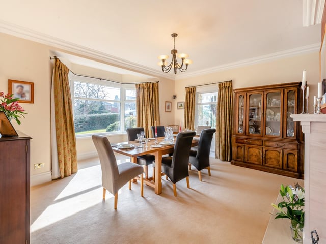 A spacious dining room, again, has a bay window and lovely fireplace.
