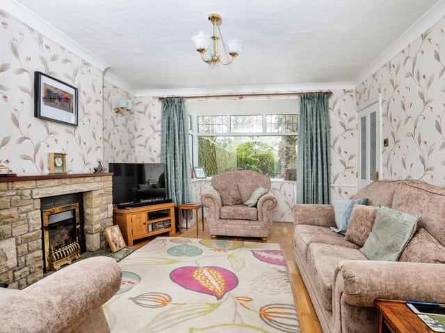 The cottage lounge, with a central fireplace and a bay window.