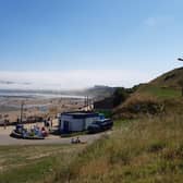 Scarborough castle and headland shrouded in sea fret while North Bay beach basks in sunshine on Saturday