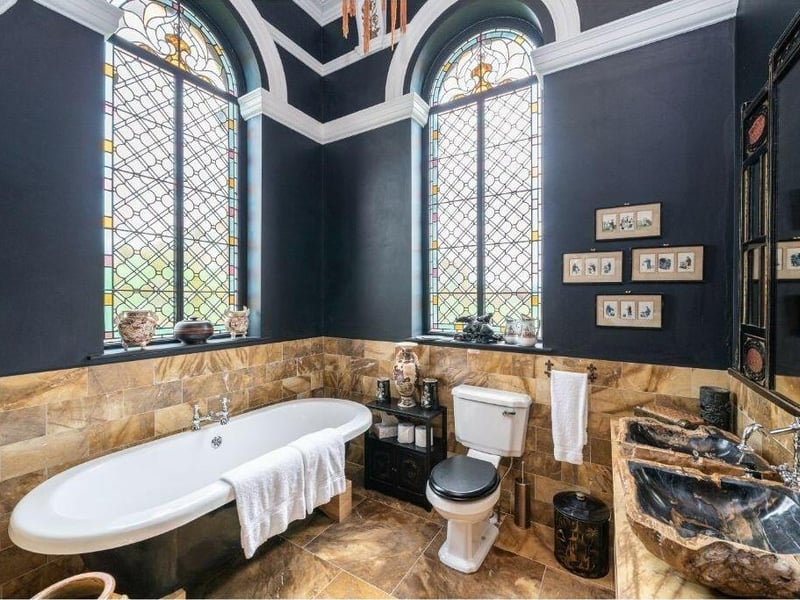 Another luxurious marble bathroom, with feature stained glass windows.