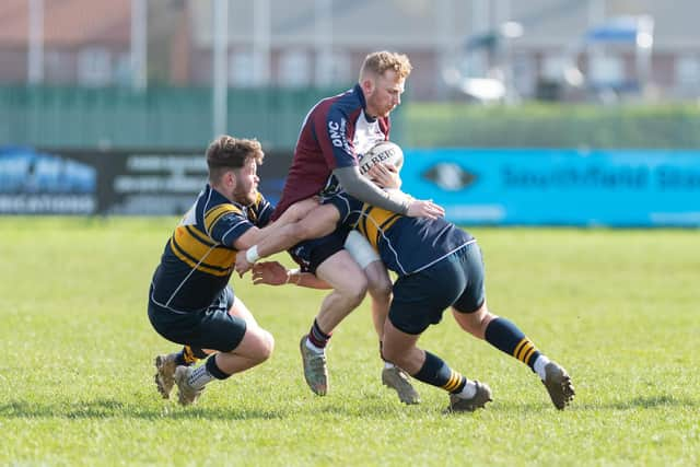 A pair of Bridlington players halt Connor Ward.