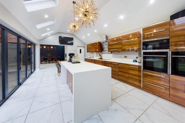 The sleek and modern kitchen has bi-folding doors along one wall, ideal for the summer.