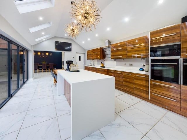 The sleek and modern kitchen has bi-folding doors along one wall, ideal for the summer.