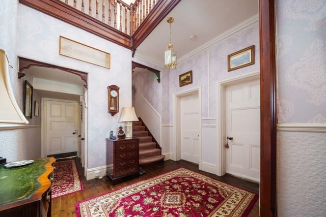 The welcoming hallway leads to several rooms, and has a staircase to the first floor.