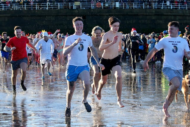 Boxing Day dippers run into the sea.