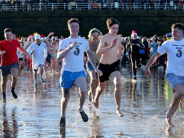 Boxing Day dippers run into the sea.