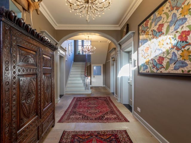 The stunning main hallway, with archway and stairs leading up.