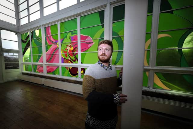 Woodend Gallery curator Joel Hague admires Kate Genever's installation bee orchid