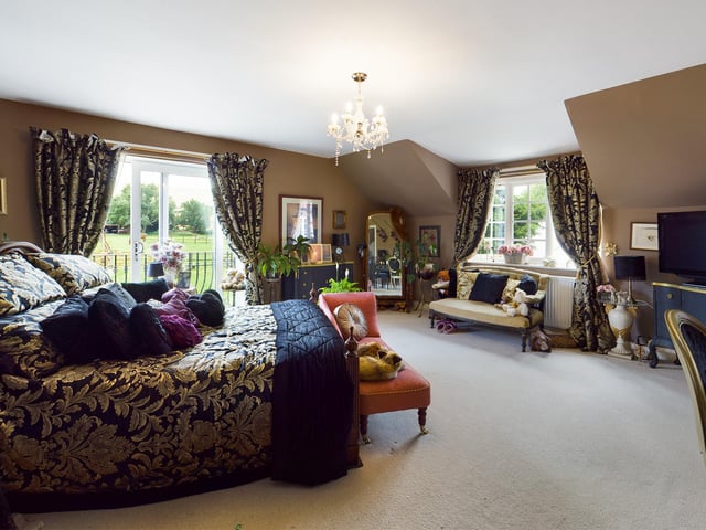 The master bedroom has its own dressing room with wardrobes, an en suite bathroom, and sliding doors out to a balcony.