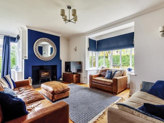 The lounge has a warming log burner at its centre, with a deep bay window adding space and light.
