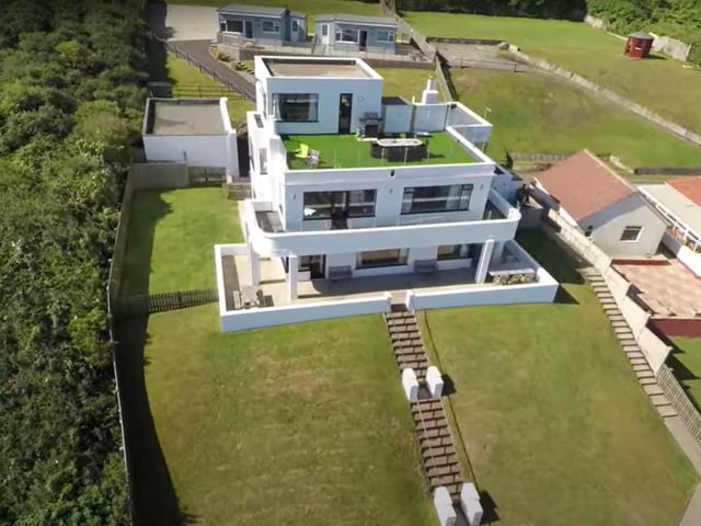 The striking art deco style building is currently divided in to two large, sea view apartments, with four beach chalets and a games room.