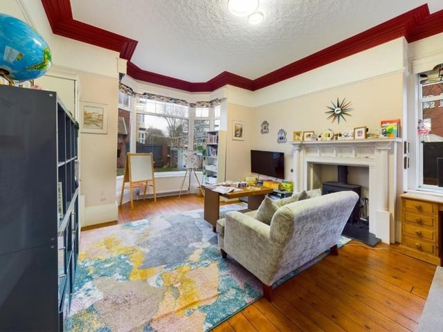 This second reception room has a log burner, and a deep bay window.