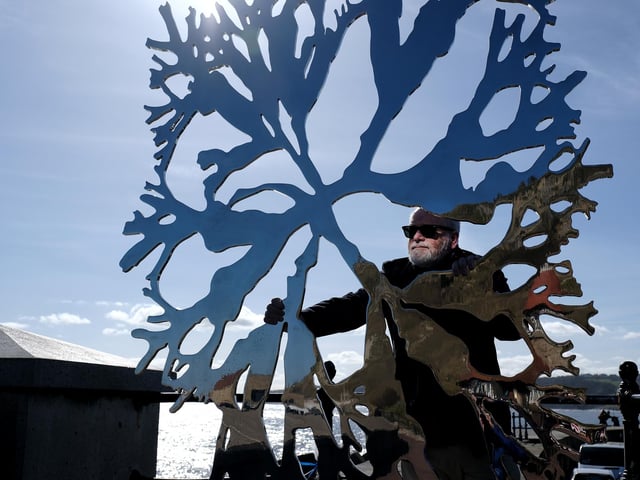 Kane Cunningham looks through the sculpture