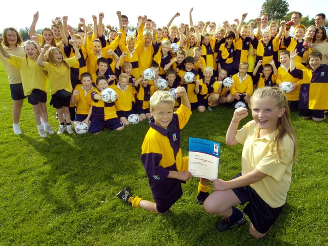 George Pindar Community Sports College receives the FA Charter Standard for Schools. Connor Myerscough (front, left) and Emma Cairney (front, right) show off the certificate as pupils and staff celebrate.