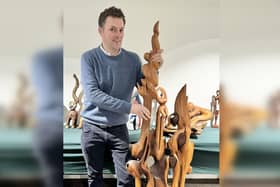 Auctioneer Will Duggleby with a large Skelton wall sculpture.