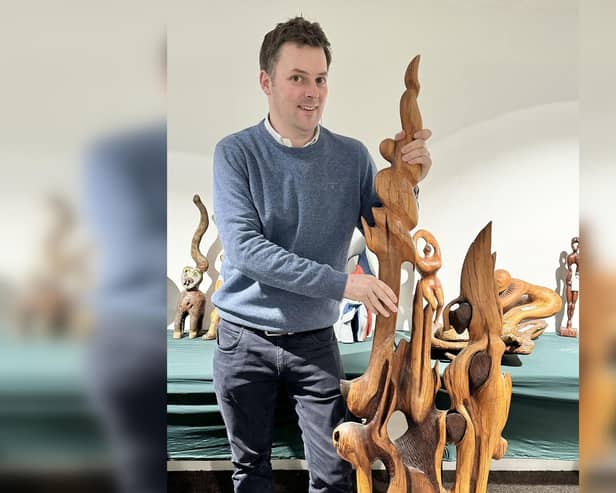 Auctioneer Will Duggleby with a large Skelton wall sculpture.