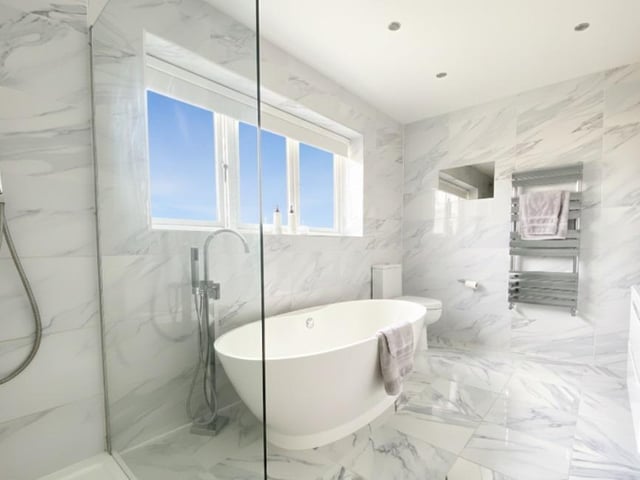 A contemporary en suite facility with stand-alone bath and walk-in shower.