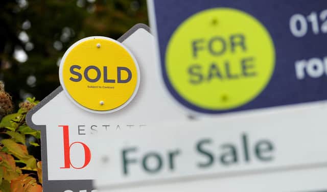 File photo of a sold and for sale signs.