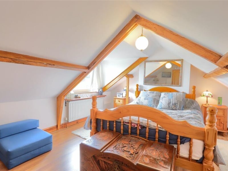A beamed bedroom with plenty of natural light.
