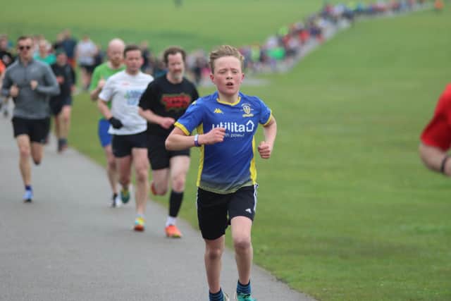A young runner gives it their all at the five-kilometre race on Saturday.