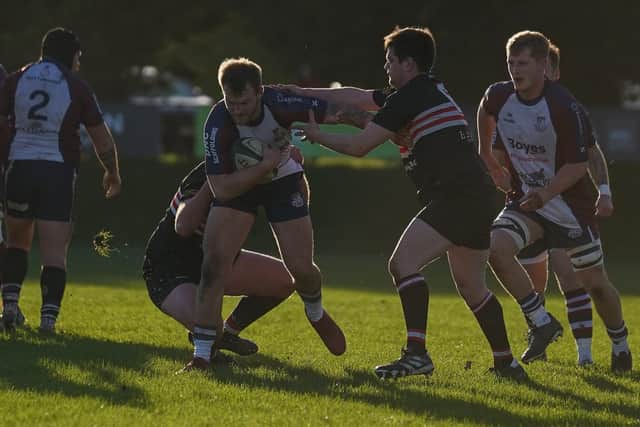 Drew Govier tries to power through the Old Brods players. Photo by Charlie Hopper