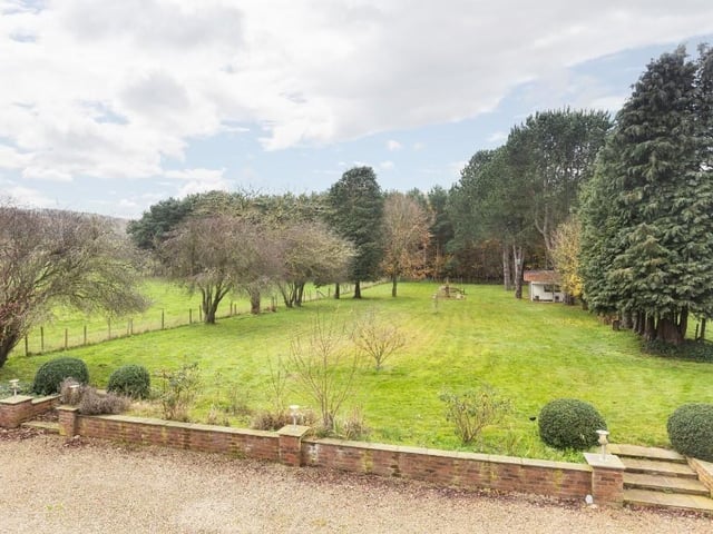 A sizeable garden bordered by open countryside.