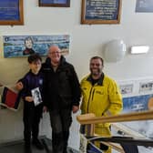Ernie and his grandad Bobbie Buttle holding a photograph of Mr Purvis with volunteer crew members Peter Sanderson, AJ Shepherd and James Mather.