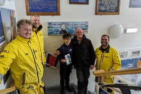 Ernie and his grandad Bobbie Buttle holding a photograph of Mr Purvis with volunteer crew members Peter Sanderson, AJ Shepherd and James Mather.