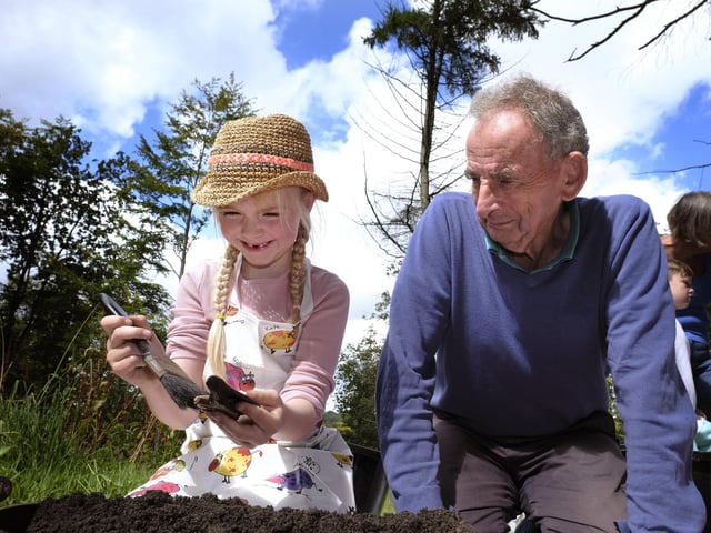 Freya cleans a part of and animal jawbone with Mick overseeing.